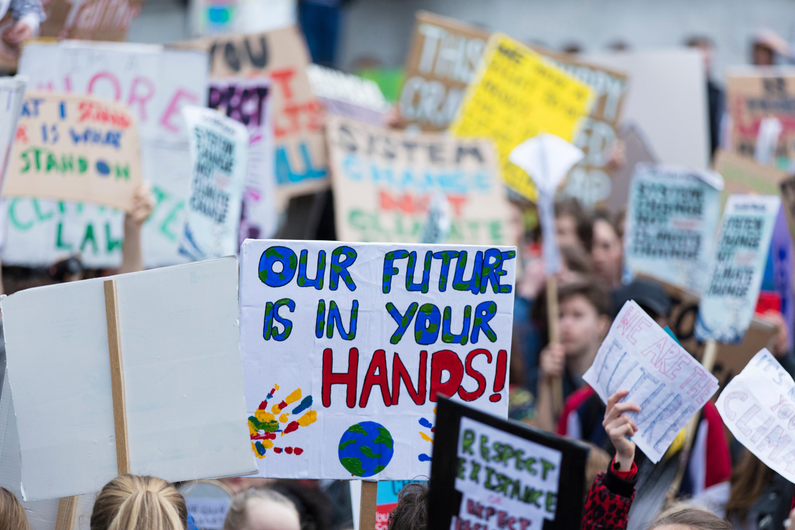 Jemand hält auf einer Demo ein Schild hoch