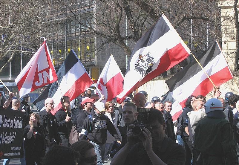 Menschen protestieren mit rechtsextremistischen Flaggen